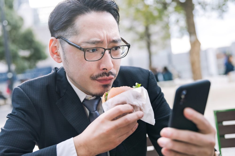スマホをイジる男